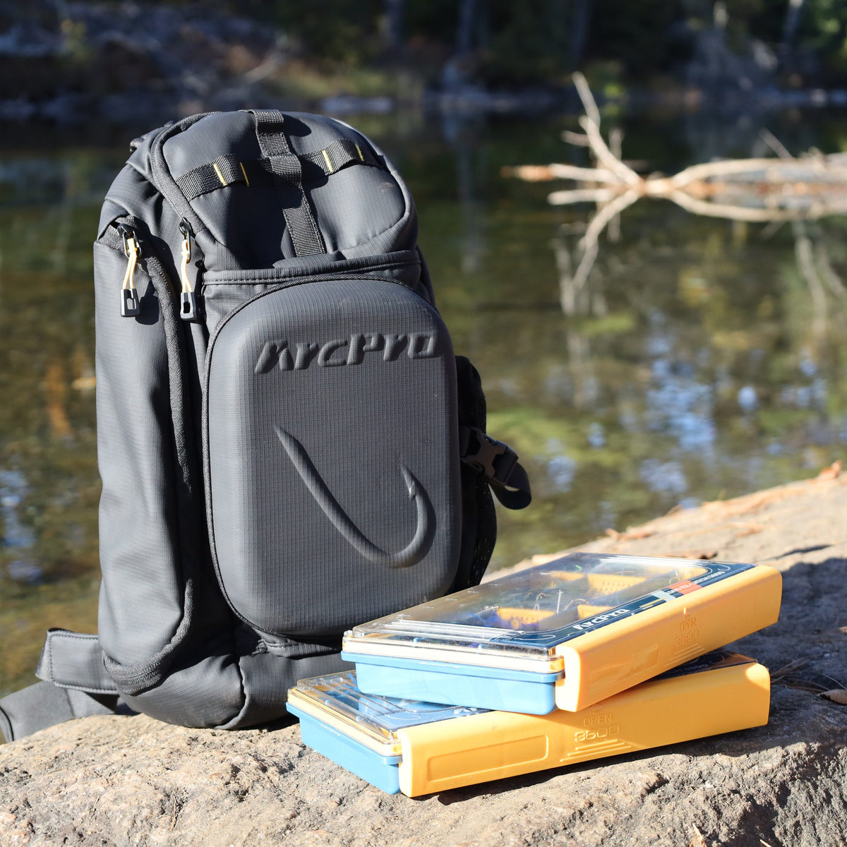 Sling pack and two 3600 tackle boxes by the water