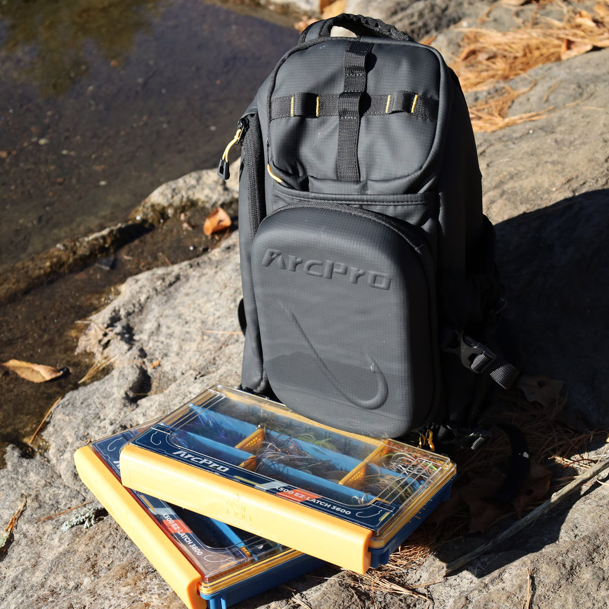 Sling pack standing on a rock with two 3600 tackle boxes in front