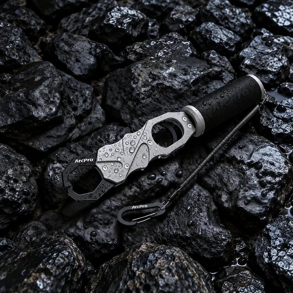 The ArcPro one-finger aluminum lip gripper with its lanyard on wet black rocks